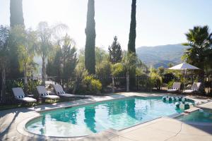 a swimming pool with chairs and trees and mountains at Villa on 5 Acre Vineyard Equestrian Estate, Pool & Hot tub, Events in Murrieta