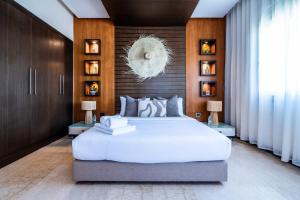 a bedroom with a large white bed and wooden walls at Penthouse d'Exception, Terrasse et Piscine Privée in Bouznika