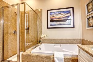 une salle de bain avec baignoire et douche dans l'établissement Stunning Litchfield 2BR Condo at Seaside Inn, à Pawleys Island