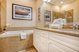 une salle de bain avec une baignoire et un lavabo et une baignoire dans l'établissement Stunning Litchfield 2BR Condo at Seaside Inn, à Pawleys Island