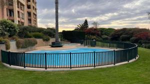 a fence around a swimming pool in a park at PAPUDO ReW in Papudo