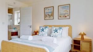 a bedroom with a large white bed with blue pillows at Weldon Road - Townhouse Overlooking the Park with Parking in Swanscombe +35 photos