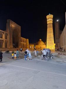 un gruppo di persone in piedi davanti a un edificio di Omar Family Resort Mekhtar anbar str 45 a Bukhara