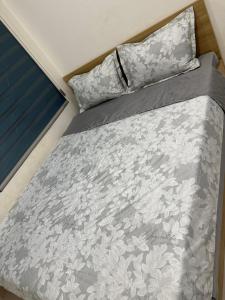 een bed met een grijs en wit dekbed en kussens bij Meimei home in Ðặng Xá