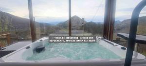a jacuzzi tub with a sign in it with a mountain at CA Granja Paraíso, Oasis Rural & Bienestar in Cangas de Onís +230 photos