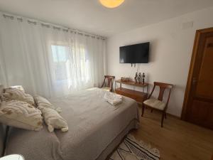 a bedroom with a bed and a television and a chair at Apartamento Ramon in Tarragona