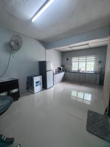 an empty room with a kitchen with a refrigerator at Homestay Pangkor Ann in Pangkor +4 photos