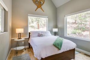a bedroom with a bed and two windows at Private Deck Secluded Fairplay Cabin in Fairplay