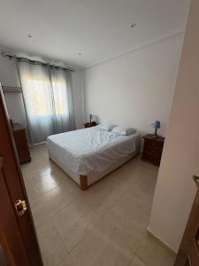 a white bedroom with a bed and a window at Brisa Azul in Playas de Vera +47 photos