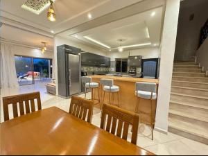 a kitchen with a wooden table and bar with chairs at villa Folki in Oulad Zbir