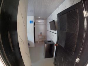 a bathroom with a black door and a hallway at Alojamiento blue castle in San Andrés