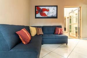 Un sofá azul con almohadas en una sala de estar. en Gaviota Family, en Guadalajara