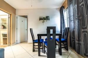 Un comedor con una mesa y sillas negras. en Gaviota Family, en Guadalajara 20 fotos más