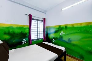 a bedroom with a green wall and a window at Hotel O A Star Lodge in Trichūr +21 photos