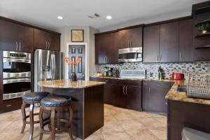 a kitchen with wooden cabinets and a island with bar stools at Spacious Retreat for Crews, Corporates & Families in Houston