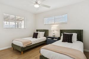 a bedroom with two beds and a ceiling fan at Bray House - Epic Shared Backyard - Pool - Games in Phoenix +31 photos