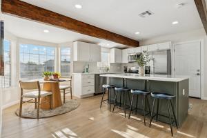 a kitchen with white cabinets and a green island with bar stools at Bray House - Epic Shared Backyard - Pool - Games in Phoenix