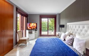 a bedroom with a large bed with a blue rug at Luxury 3 Beds Villa Inside Resort in Estepona +28 photos