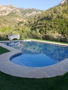 a swimming pool with blue water in front of a mountain at Fuente Los Avellanos in Villanueva del Arzobispo