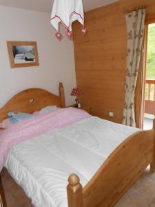 Villard-sur-DoronにあるLes Alpagesの部屋に木製のベッドがある寝室