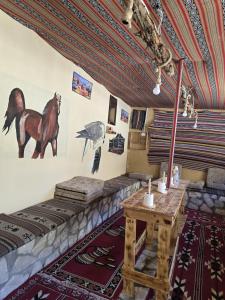 a room with a table and a horse on the wall at Friends of Dana Hotel in Dana