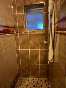 a bathroom with a shower with a window at Nalana Guest House in Thaba Nchu