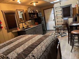a bedroom with a bed and a kitchen with a sink at Cowboy Cabin at The Wild West 40 Homestead in Cane Beds +24 photos