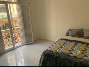 a bedroom with a bed and a door to a balcony at Appart Élégance Oran Centre in Oran