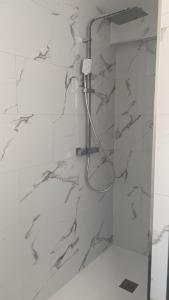 ChâteauthébaudGîtes L'Infinity - 4 Chambres的一间设有白色大理石墙壁和淋浴的浴室