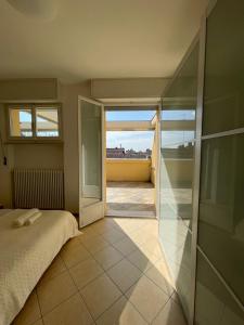 a bedroom with a bed and a view of a balcony at Historic Center Penthouse 6 minutes from the Station in Ravenna
