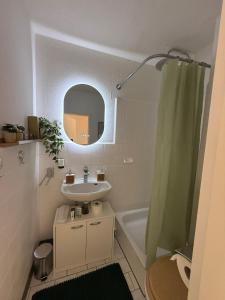 a bathroom with a sink and a mirror and a shower at Apartment Cozy Note für 2 in Bremerhaven