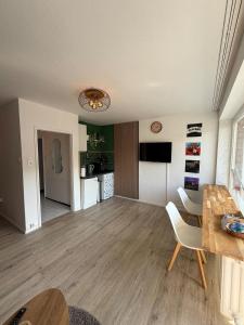 a living room with a dining table and a kitchen at Apartment Cozy Note für 2 in Bremerhaven