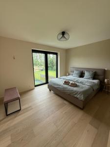 a bedroom with a large bed and a large window at Maison Impression vakantiehuis in Middelkerke