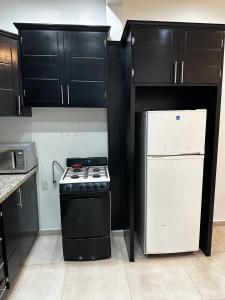 a kitchen with black cabinets and a stove and refrigerator at Casa de lujo muy cómoda de 2 pisos in San Miguel el Alto +21 photos