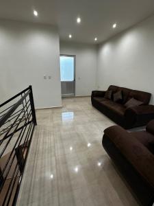 a living room with two leather couches and a window at Casa de lujo muy cómoda de 2 pisos in San Miguel el Alto