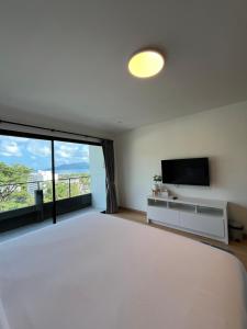 a bedroom with a large bed and a television at Hill Bay Suites Hotel in Patong Beach