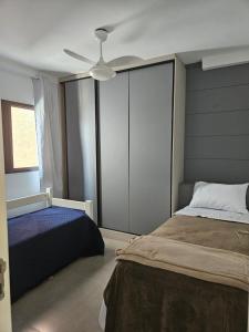a bedroom with two beds and a ceiling fan at Apto 100m da praia in Caraguatatuba +32 photos