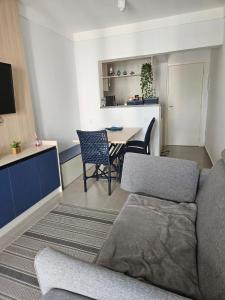 a living room with a couch and a table at Apto 100m da praia in Caraguatatuba