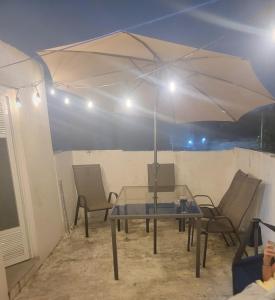 a table and chairs under a white umbrella at Aguilas House 2 Alojamiento entero 3 habitaciones in Guadalajara