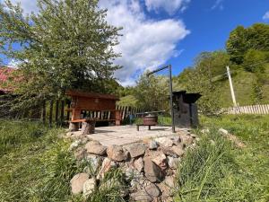a bench sitting on a stone wall in front of a house at Rai Village in Băniţa