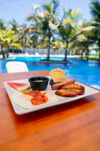 a plate of food on a table next to a pool at Villas La Mar in Monterrico