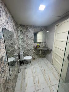 un baño con inodoro y lavabo en Novo hotel Maracaípe, en Porto de Galinhas