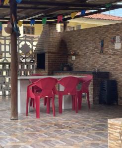 Un grupo de mesas y sillas rojas en un patio. en Novo hotel Maracaípe, en Porto de Galinhas 1 foto más