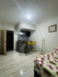 Habitación con cama y cocina con sillas amarillas. en Novo hotel Maracaípe, en Porto de Galinhas