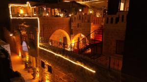 Una vista de un castillo de noche con luces. en Ali paşa konağı mardin, en Mardin