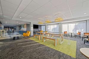 an office with desks and chairs and tables and windows at Spark by Hilton Tuscaloosa University in Tuscaloosa