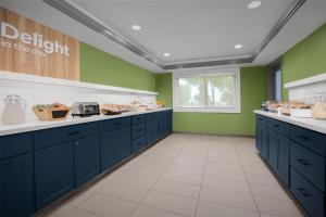a kitchen with blue cabinets and green walls at Spark by Hilton San Jose Airport in San Jose