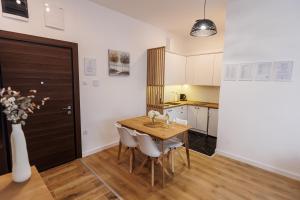 a kitchen and dining room with a table and chairs at Apartman Bonus in Palić