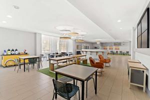 a cafeteria with tables and chairs and a kitchen at Spark by Hilton Little Rock West in Little Rock