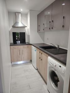 una cocina con lavadora y fregadero en Charming quiet studio with pool, 
